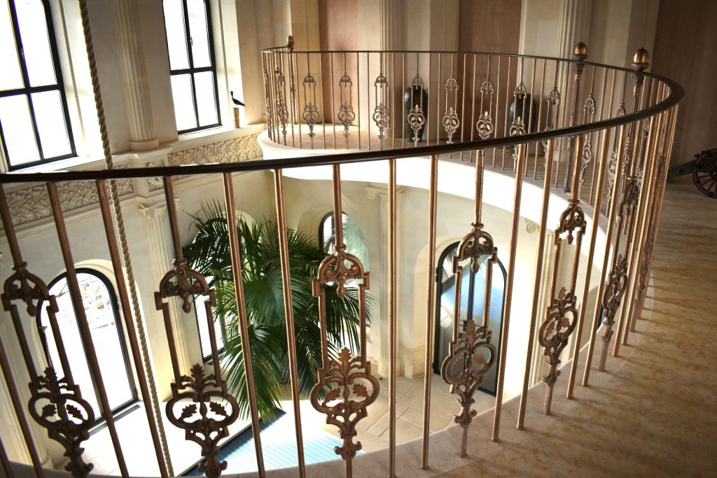 Solid bronze balustrade and handrail on a pool balcony in a castle.