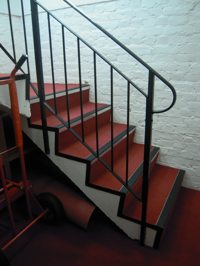Foot of staircase with metal banisters in St James Church in Gerrards Cross.