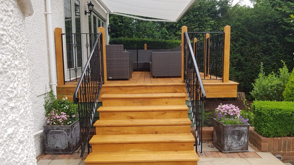 Wooden steps leading to decking with metal railing panels.