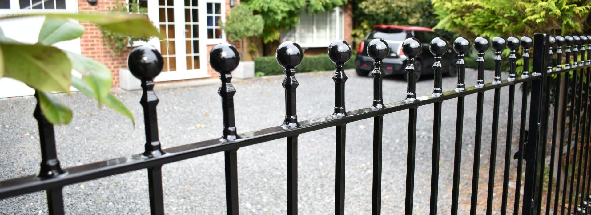 Wrought iron gates and railings made by The Blacksmith Shop and fitted at the front of a residence.