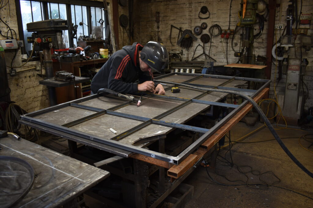 Making metal glazed internal doors and partitions in The Blacksmith Shop forge.