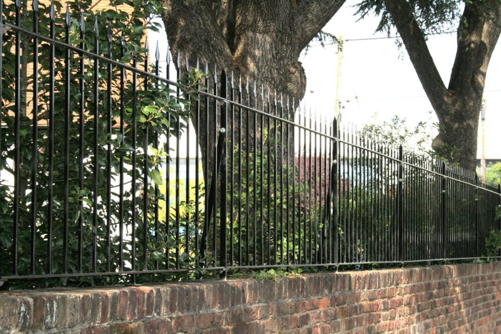 Daleside wrought iron railings fitted on top of a brick wall.