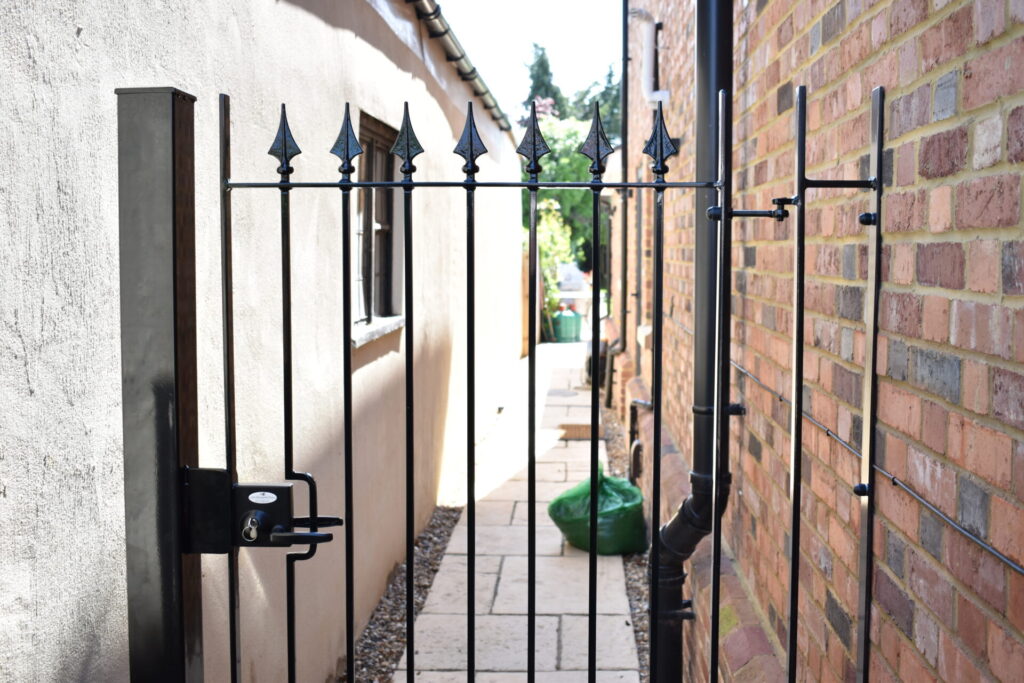 A Daleside wrought iron side gate between two properties.